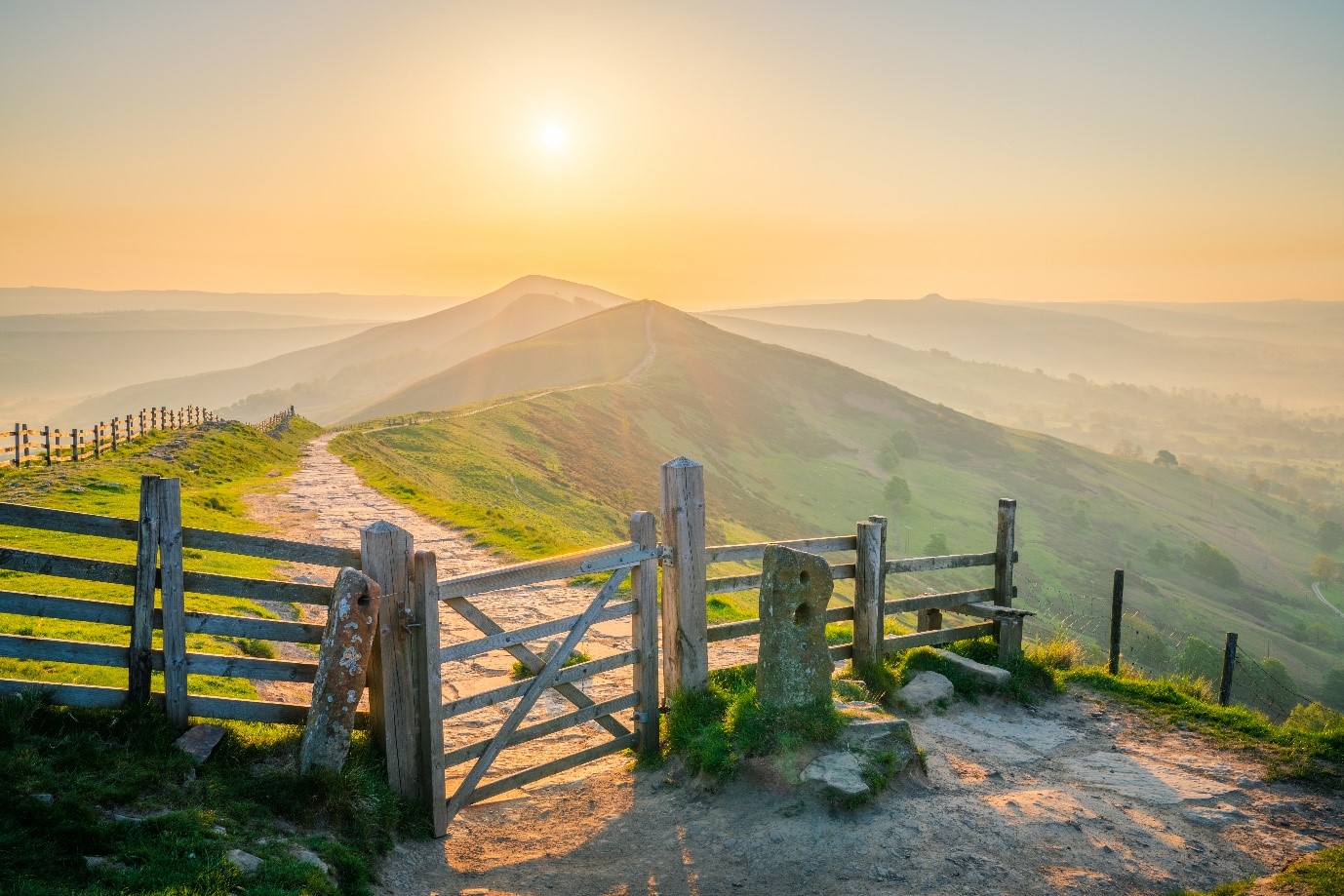 sweeping landscape of the peak district, with hills, greenery and lake