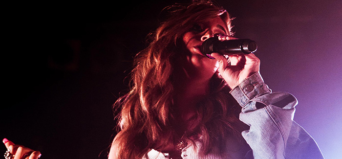 a female singing into a microphone on a stage in a nightclub