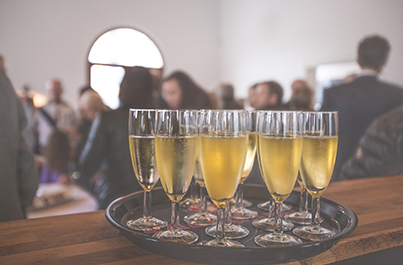 glasses of champagn on a tray ready to be served to a room full of people