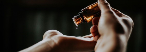 massage therapist pouring essential oil onto her hand at the ren