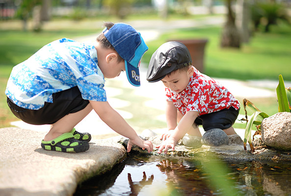 two kids playing together in a stream 